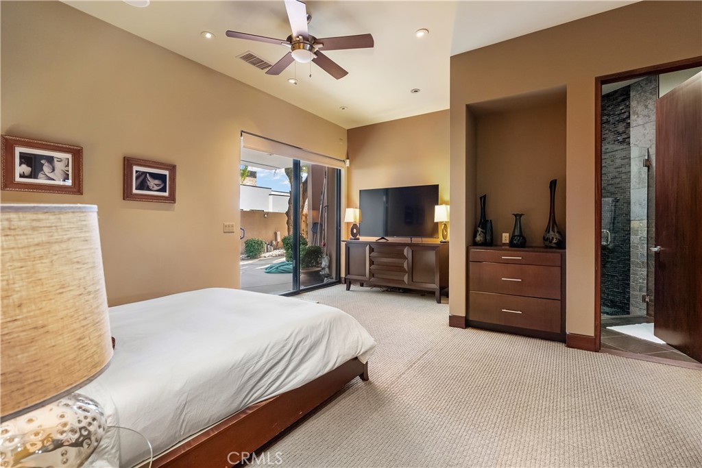 68 Royal St Georges Way Rancho Mirage, CA 92270 - Photo 59 of 75 a bedroom with a bed and a flat tv screen on dresser