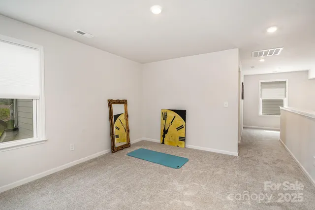 a view of an empty room with window and a livingroom