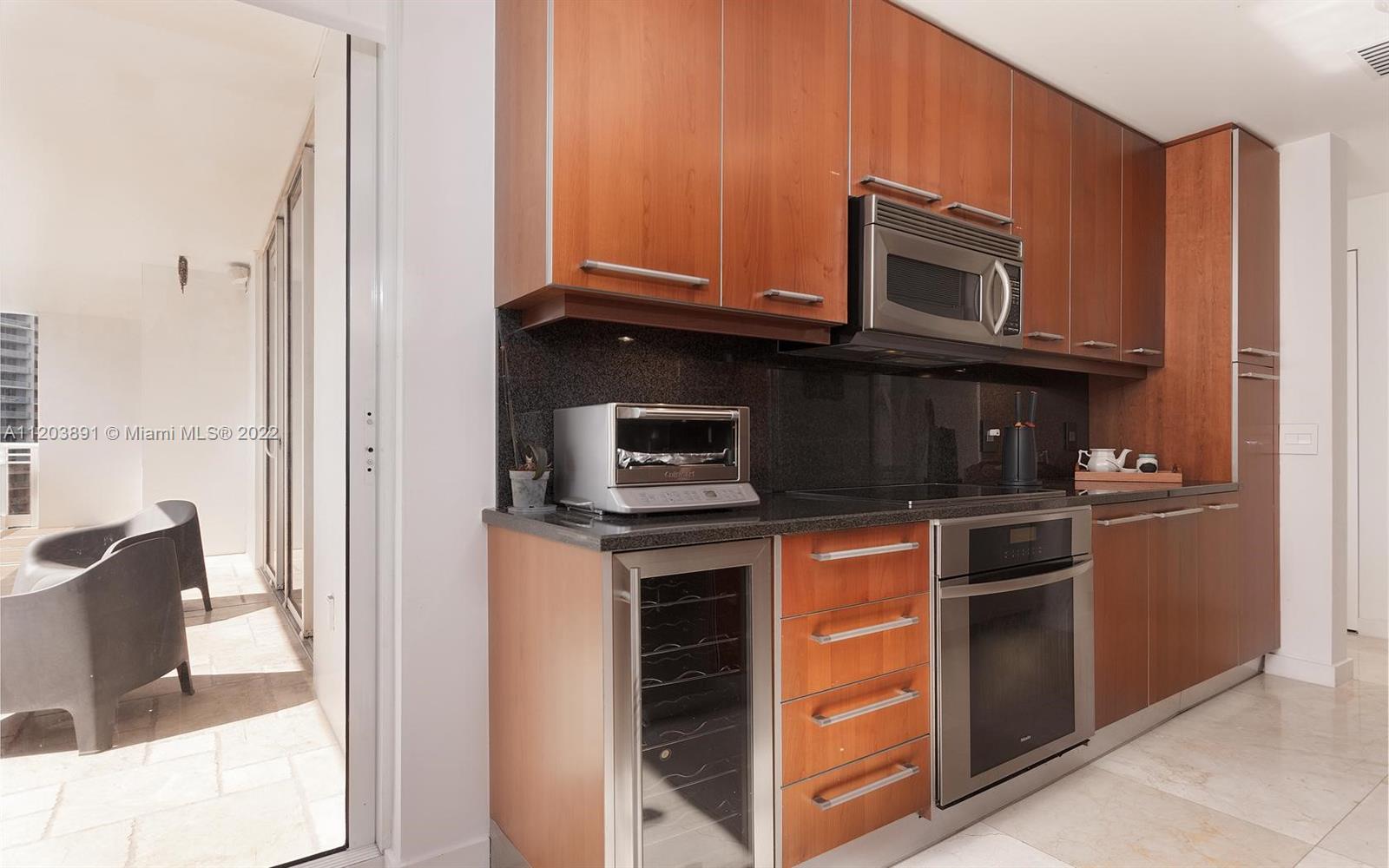 901 Brickell Key Boulevard, Unit 2503 Miami, FL 33131 - Photo 13 of 19 a kitchen with stainless steel appliances granite countertop a stove microwave and refrigerator