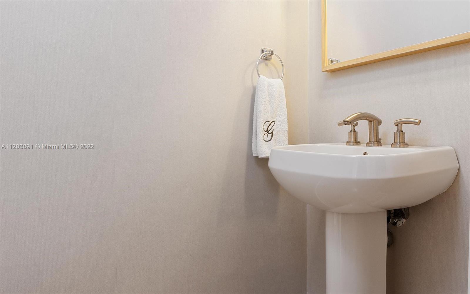 901 Brickell Key Boulevard, Unit 2503 Miami, FL 33131 - Photo 18 of 19 a bathroom with a sink and a mirror