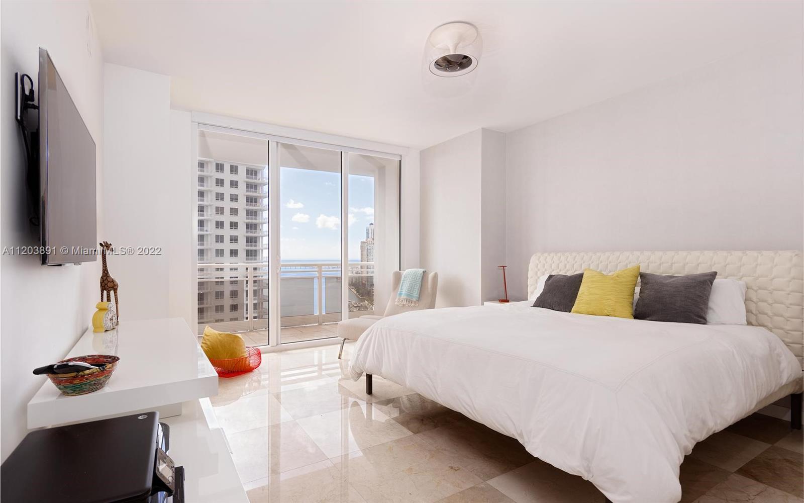 901 Brickell Key Boulevard, Unit 2503 Miami, FL 33131 - Photo 6 of 19 a bedroom with a bed a flat screen tv and window