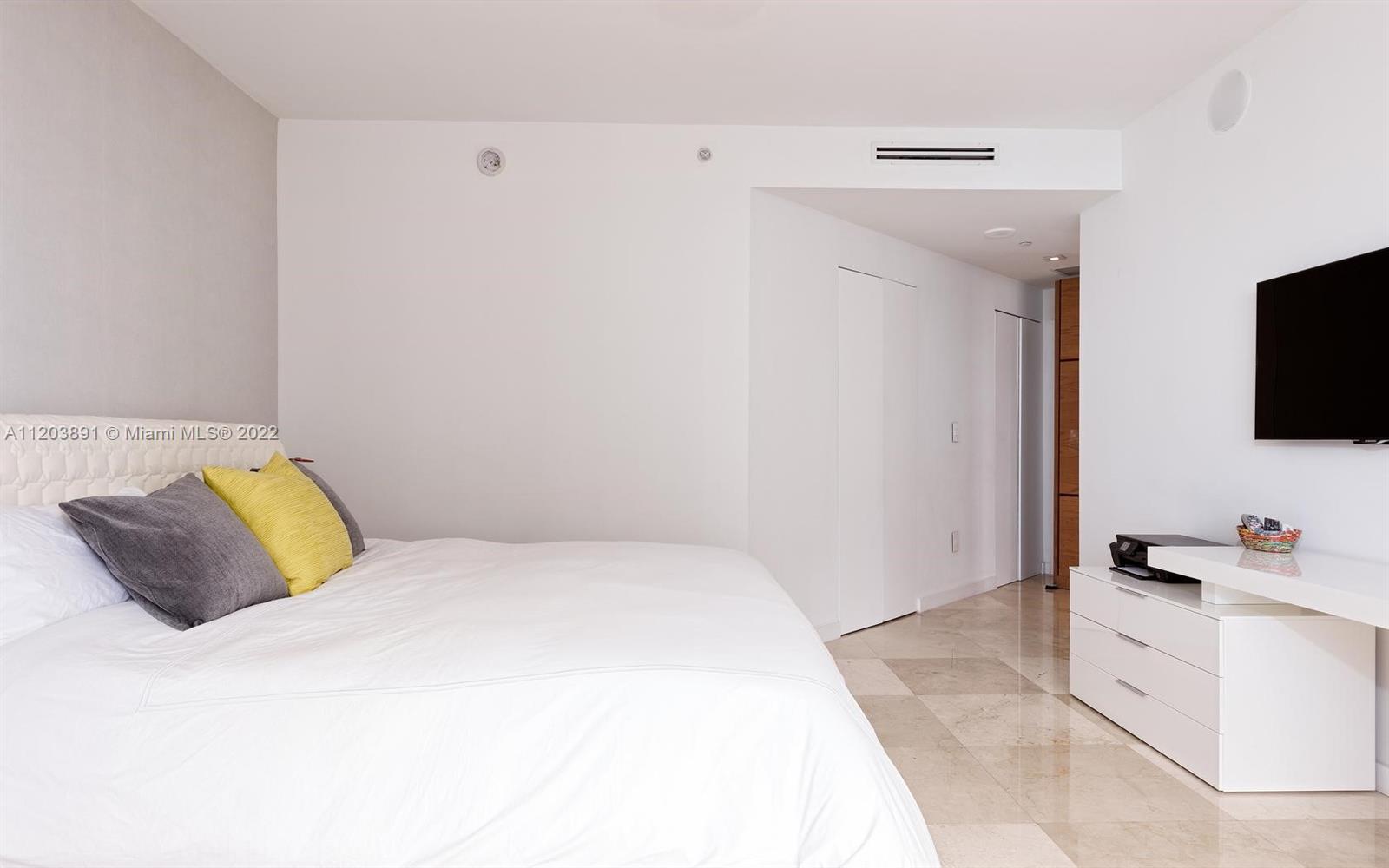 901 Brickell Key Boulevard, Unit 2503 Miami, FL 33131 - Photo 7 of 19 a bedroom with a bed and a flat screen tv