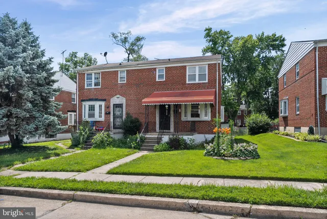 a front view of a house with a yard and potted plants
