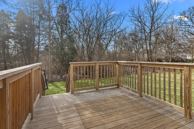 a kitchen with stainless steel appliances granite countertop a stove a refrigerator a white table and chairs with wooden floor