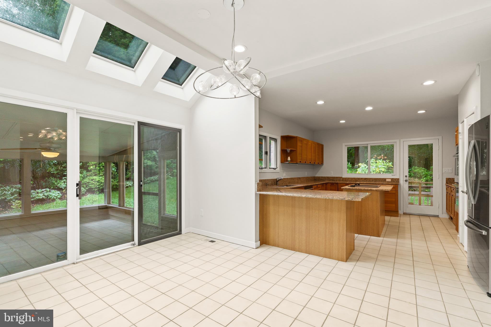 7805 Laurel Leaf Drive Potomac, MD 20854 - Photo 8 of 13 a kitchen with stainless steel appliances kitchen island a chandelier in front of it