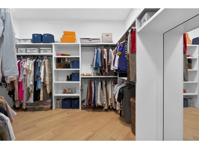 a view of walk in closet with clothes and shoes
