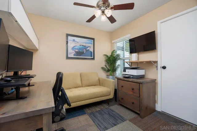 a living room with furniture a flat screen tv and kitchen view