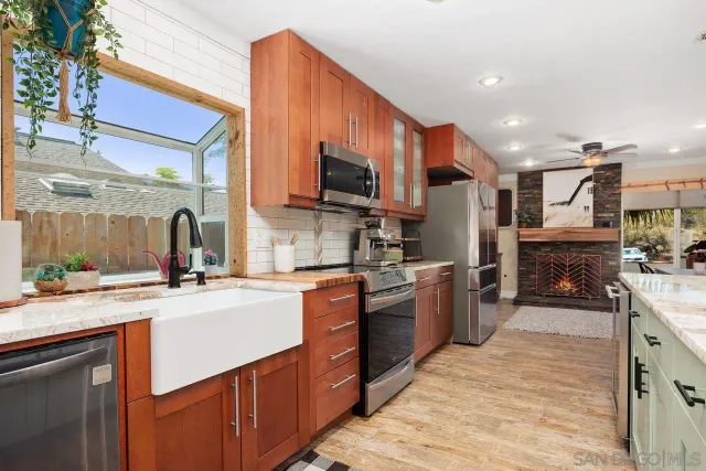 a kitchen with stainless steel appliances granite countertop a sink stove and refrigerator