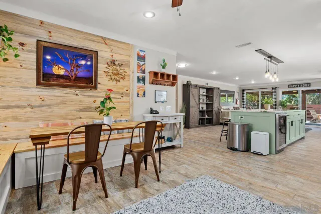 a living room with furniture kitchen view and a flat screen tv