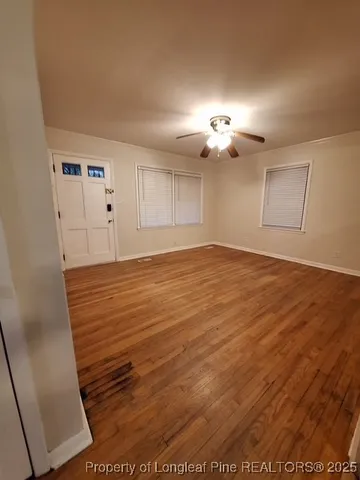 a view of empty room with wooden floor
