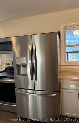 a metallic refrigerator freezer sitting in a kitchen