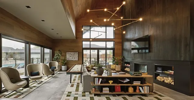 a living room with furniture fireplace and large windows