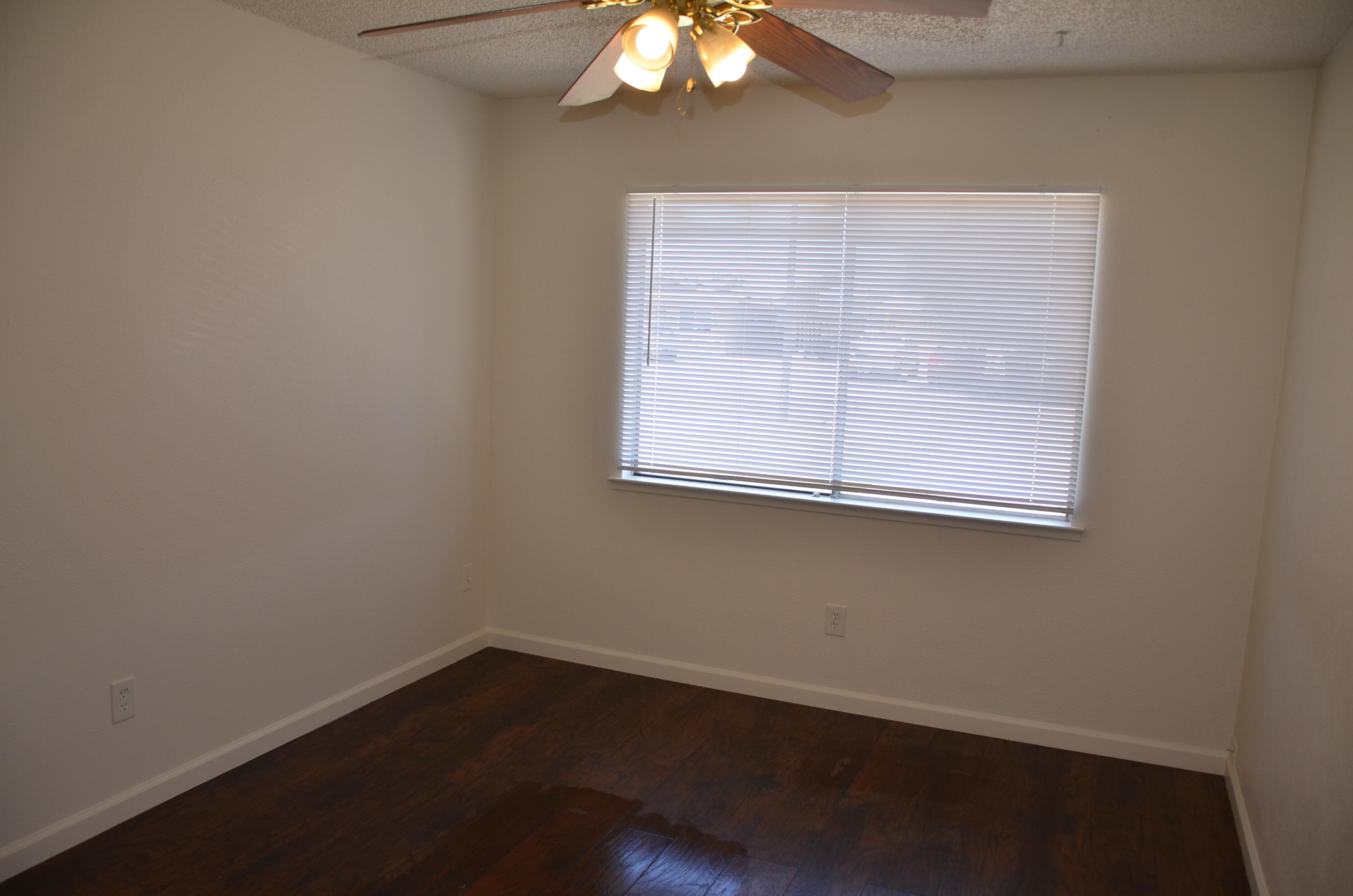 339 West Spring Lane Lemoore, CA 93245 - Photo 17 of 31 an empty room with wooden floor and windows