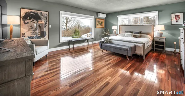 a bedroom with a bed and wooden floor