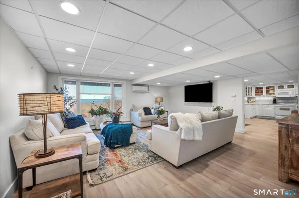 a living room with furniture a flat screen tv and a fireplace
