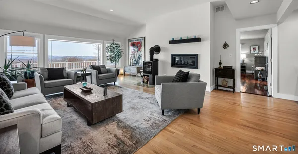 a living room with furniture large window and wooden floor