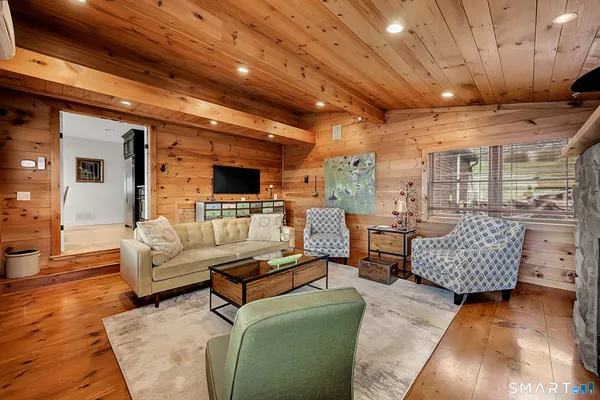 a kitchen with stainless steel appliances granite countertop a stove top oven a sink a dining table and chairs with wooden floor