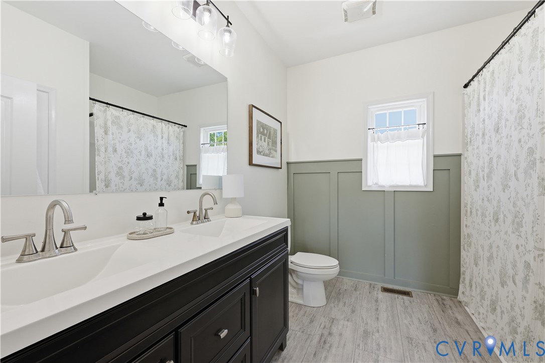 235 Stoney Point Road Cumberland, VA 23040 - Photo 27 of 35 a bathroom with a double vanity sink toilet and mirror