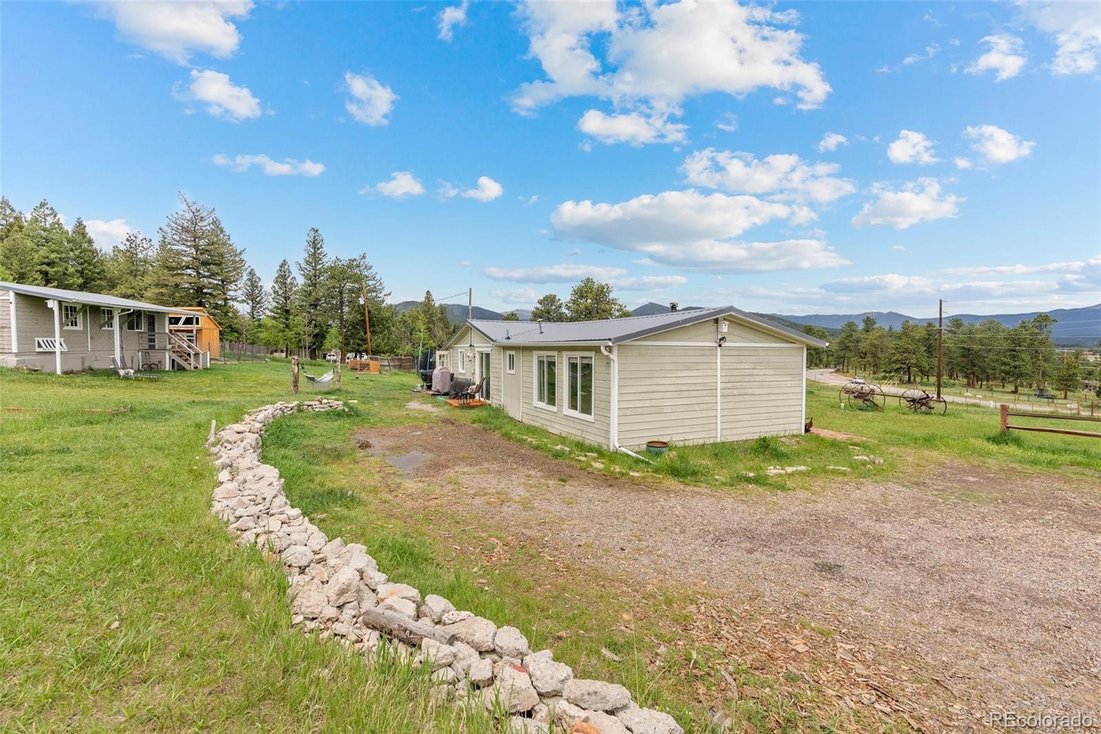 795 Burland Drive Bailey, CO 80421 - Photo 22 of 50 a view of a house with a big yard and large trees