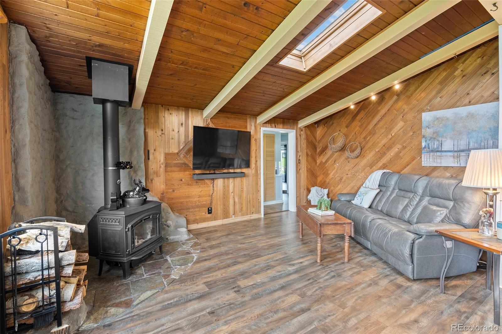 795 Burland Drive Bailey, CO 80421 - Photo 7 of 50 a living room with furniture a flat screen tv and a floor to ceiling window