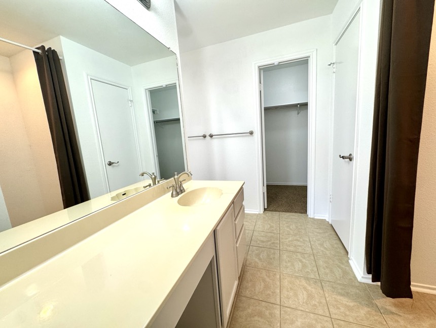 2009 Marysol Trail Cedar Park, TX 78613 - Photo 10 of 15 Bathroom featuring a walk in closet, vanity, and light tile patterned floors