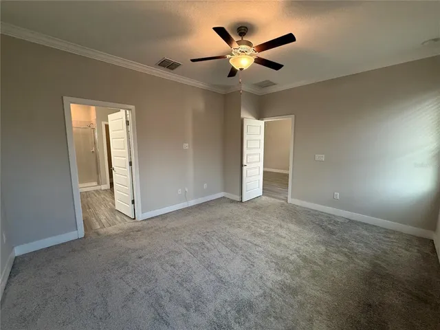 an empty room with a ceiling fan and a window