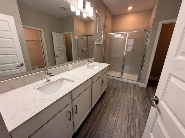 a bathroom with a double vanity sink and mirror