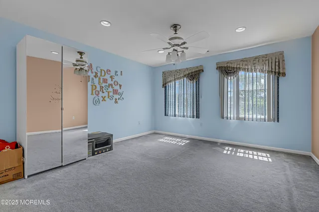 a large bedroom with a bed and a flat screen tv