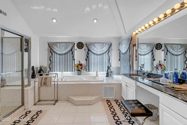 a view of a white house with a big yard potted plants and large tree