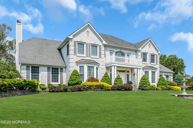 a front view of a house with garden and plants