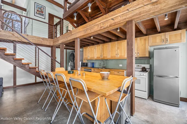 a dining area with furniture a chandelier and wooden floor