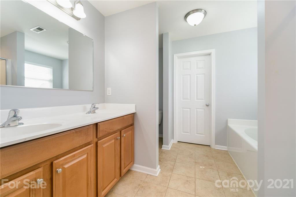 244 Lorraine Road Fort Mill, SC 29708 - Photo 19 of 33 a bathroom with a sink a mirror and a bathtub