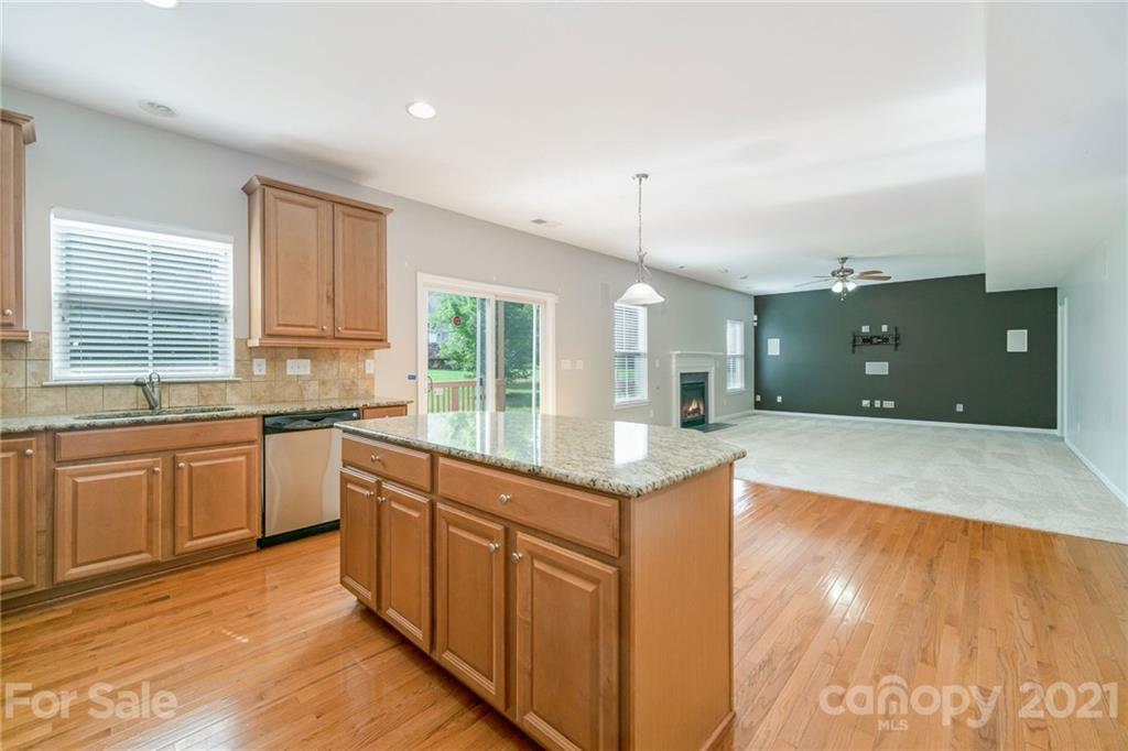 244 Lorraine Road Fort Mill, SC 29708 - Photo 5 of 33 a large kitchen with kitchen island a sink dishwasher a stove and a refrigerator with wooden floor