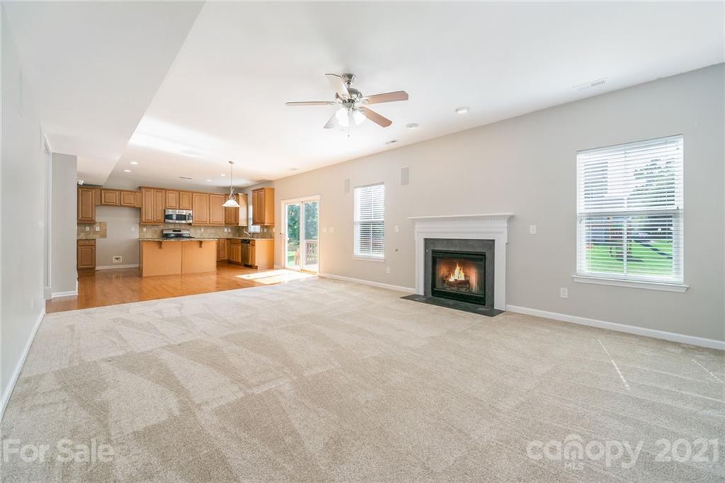 244 Lorraine Road Fort Mill, SC 29708 - Photo 10 of 33 a view of a livingroom with a fireplace a ceiling fan and windows