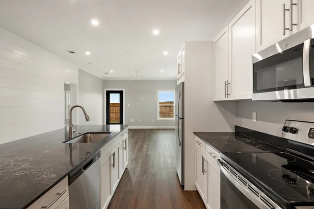 a kitchen with granite countertop a stove and a sink