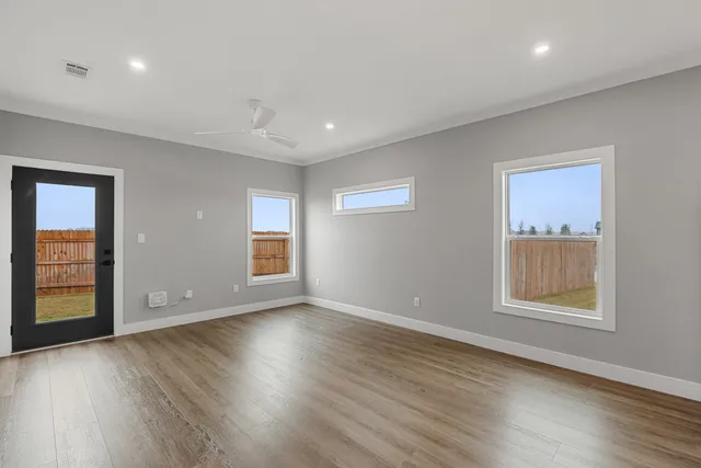 a view of an empty room with wooden floor