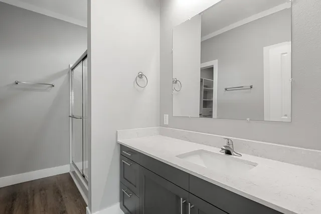 an empty room with wooden floor and a hallway