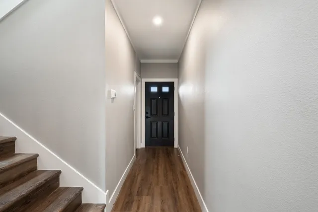 a view of a hallway with wooden floor and entryway