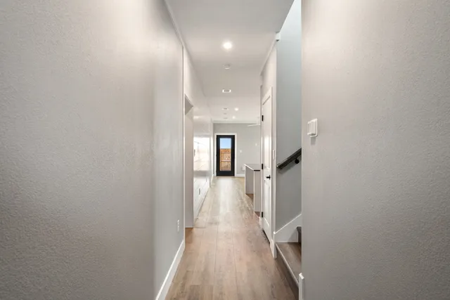 a view of a hallway with wooden floor and staircase