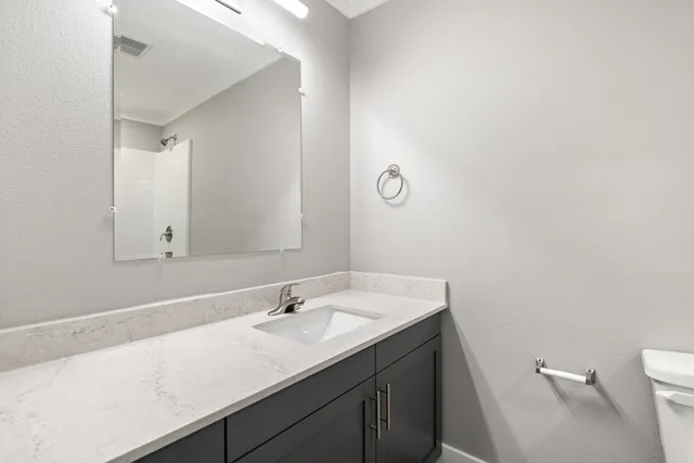 a bathroom with a sink a toilet and a mirror