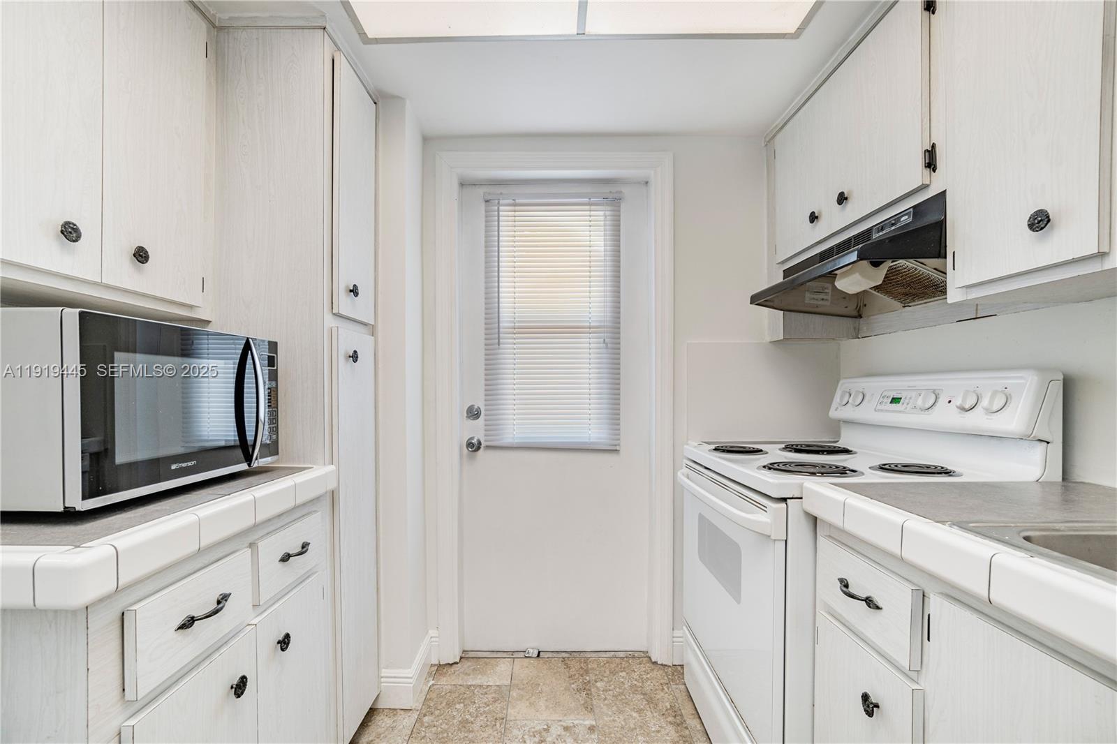 5800 Margate Boulevard, Unit 8128 Margate, FL 33063 - Photo 11 of 27 a kitchen with stainless steel appliances granite countertop white cabinets and a stove a oven with white countertops