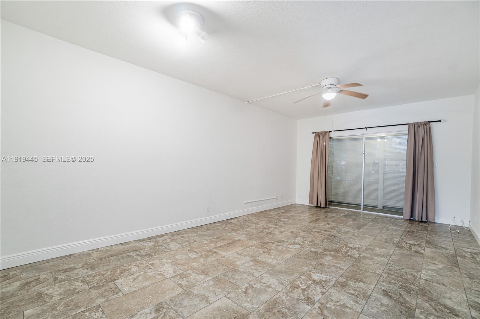 5800 Margate Boulevard, Unit 8128 Margate, FL 33063 - Photo 5 of 27 an empty room with a chandelier fan and windows