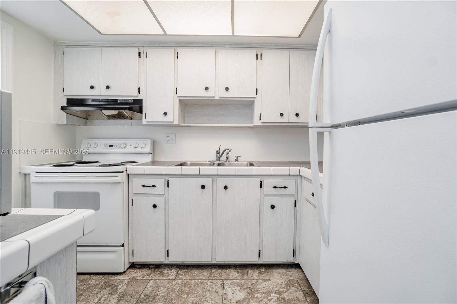 5800 Margate Boulevard, Unit 8128 Margate, FL 33063 - Photo 7 of 27 a kitchen with granite countertop white cabinets and white appliances