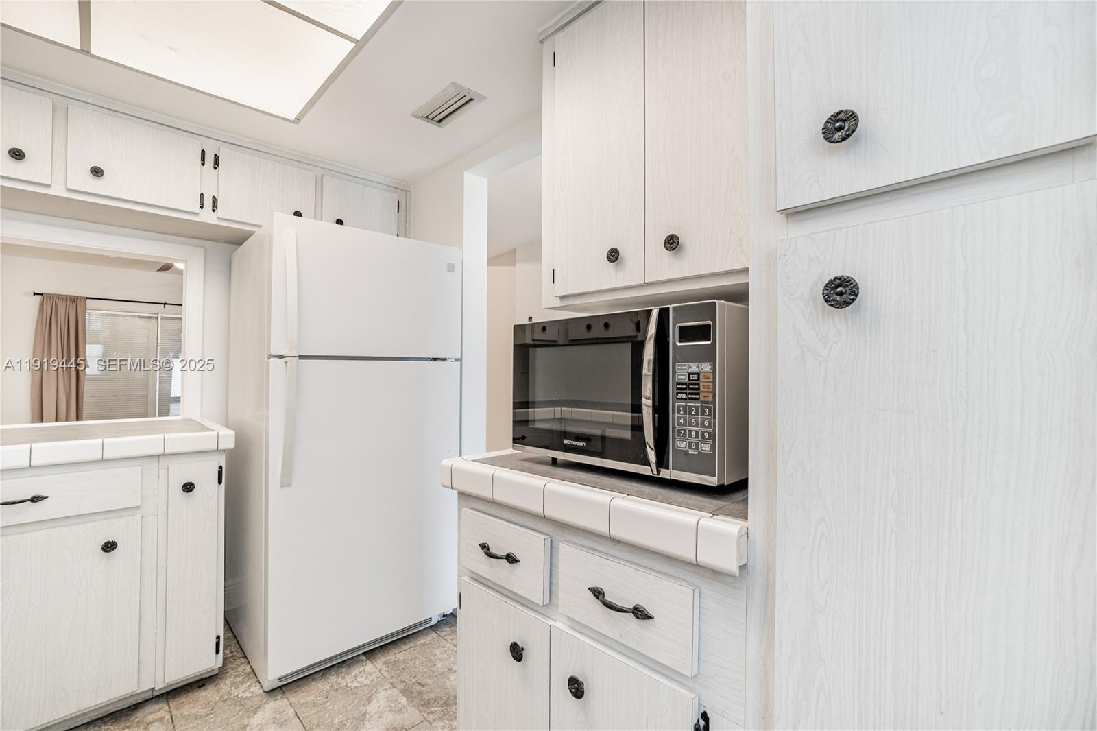 5800 Margate Boulevard, Unit 8128 Margate, FL 33063 - Photo 10 of 27 a white refrigerator freezer and a stove sitting inside of kitchen