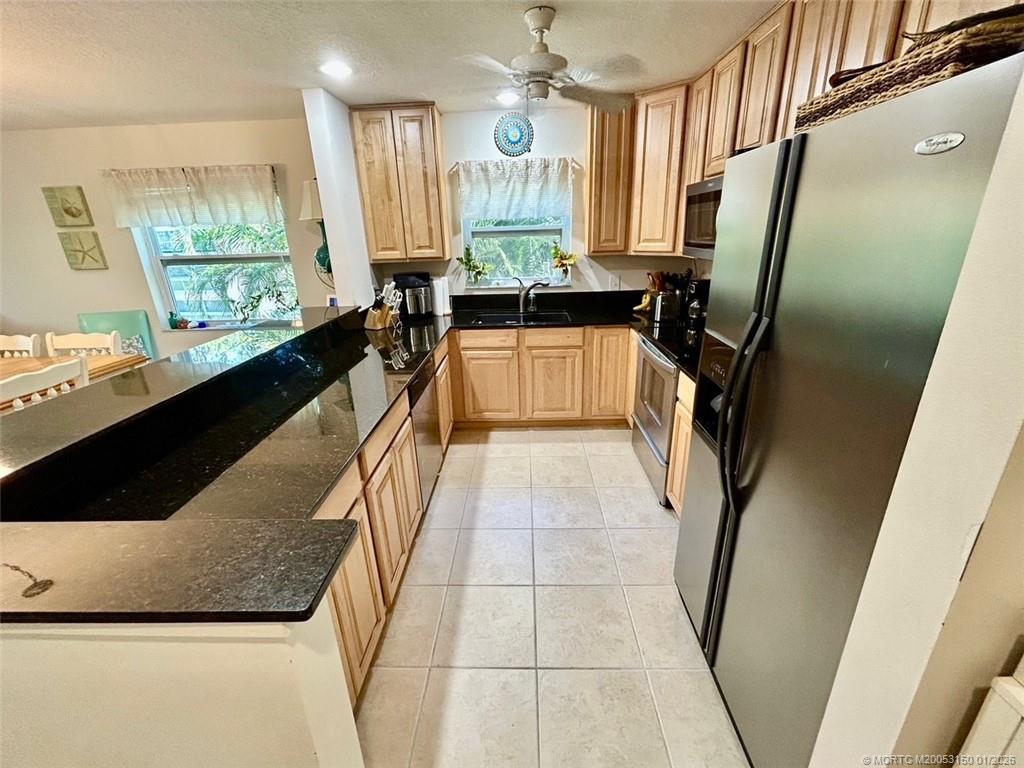 2950 Southeast Ocean Boulevard, Unit 546 Stuart, FL 34996 - Photo 11 of 33 a bathroom with a granite countertop sink a large mirror a bathtub and window