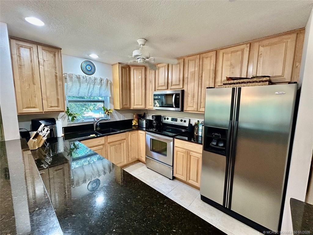2950 Southeast Ocean Boulevard, Unit 546 Stuart, FL 34996 - Photo 13 of 33 a kitchen with granite countertop stainless steel appliances a refrigerator a sink a counter space and cabinets