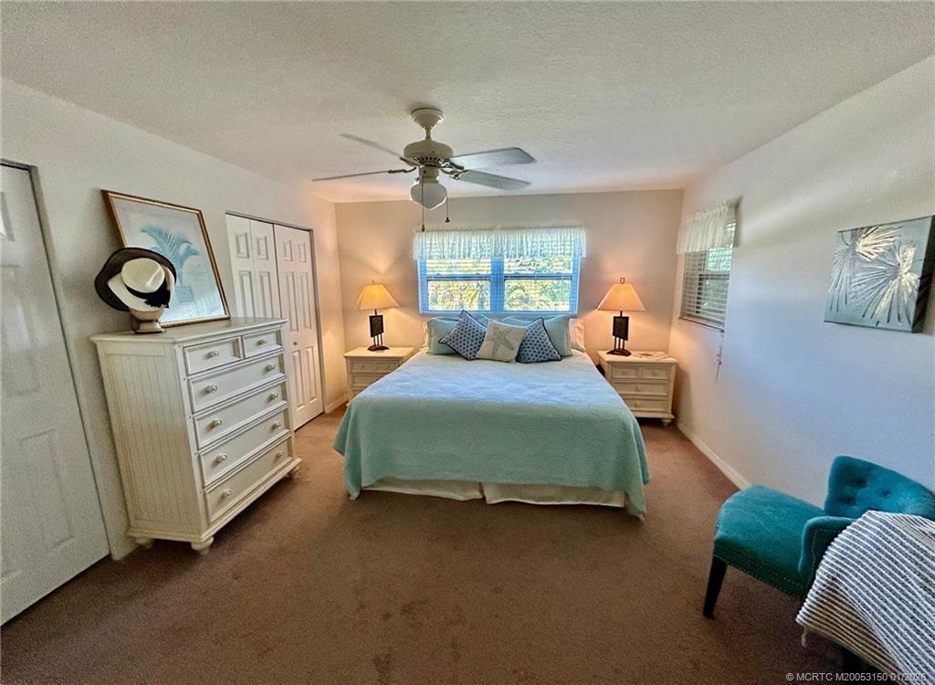 2950 Southeast Ocean Boulevard, Unit 546 Stuart, FL 34996 - Photo 14 of 33 a bedroom with a bed and a chandelier