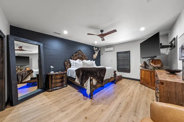 a bedroom with a bed and a flat tv screen on dresser