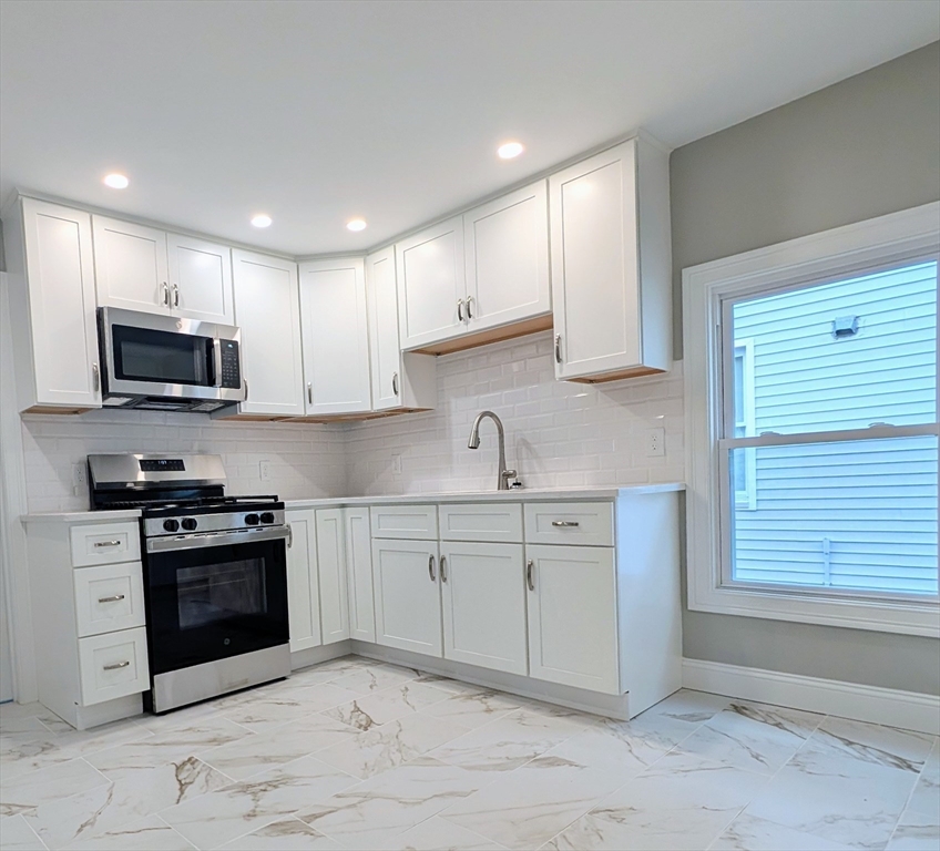 a kitchen with stainless steel appliances granite countertop a sink and a stove