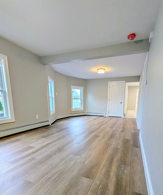 121 Whitman Street, Unit 2 New Bedford, MA 02745 - Photo 3 of 11 a view of empty room with window and wooden floor